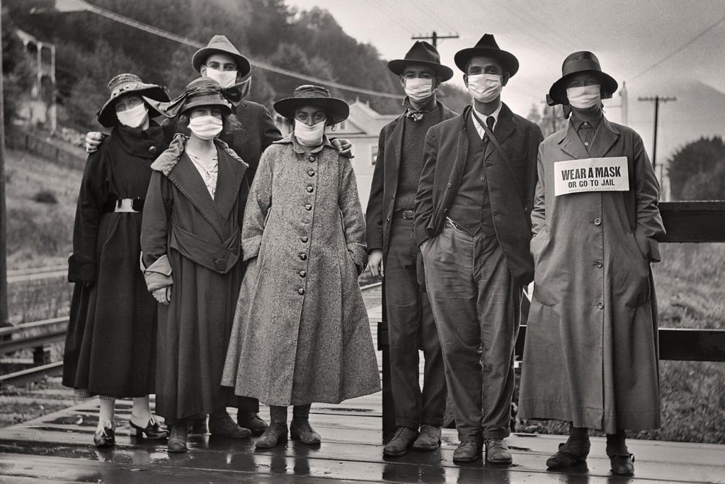 Mask Mandates In US History - The Mask Mandate of 2020 is not the first time the US has had a mask mandate.  - Rail commuters wearing white protective masks, one with the additional message “wear a mask or go to jail,” during the 1918 influenza pandemic in California.Credit...Vintage Space/Alamy