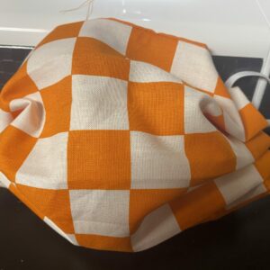 Orange & White Checkerboard Face Mask - This checkerboard face mask that is orange & white will remind you of the endzones of Neyland Stadium at the University of Tennessee. A great face mask to show off that you are a Vols fan.