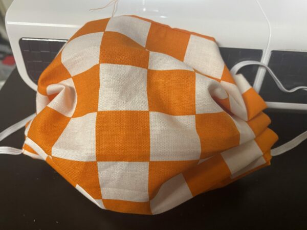 Orange & White Checkerboard Face Mask - This checkerboard face mask that is orange & white will remind you of the endzones of Neyland Stadium at the University of Tennessee. A great face mask to show off that you are a Vols fan.