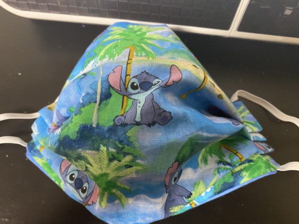 Stitch Face Mask - A Hawaiian theme with Stitch and palm trees on the face mask. #Stitch