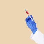 crop doctor in white uniform and blue gloves with syringe Tennessee Selected for Pfizer COVID-19 Vaccine Distribution Pilot Program, Tennessee, Pfizer, Pfizer COVID-19 Vaccine, COVID-19 Vaccine,