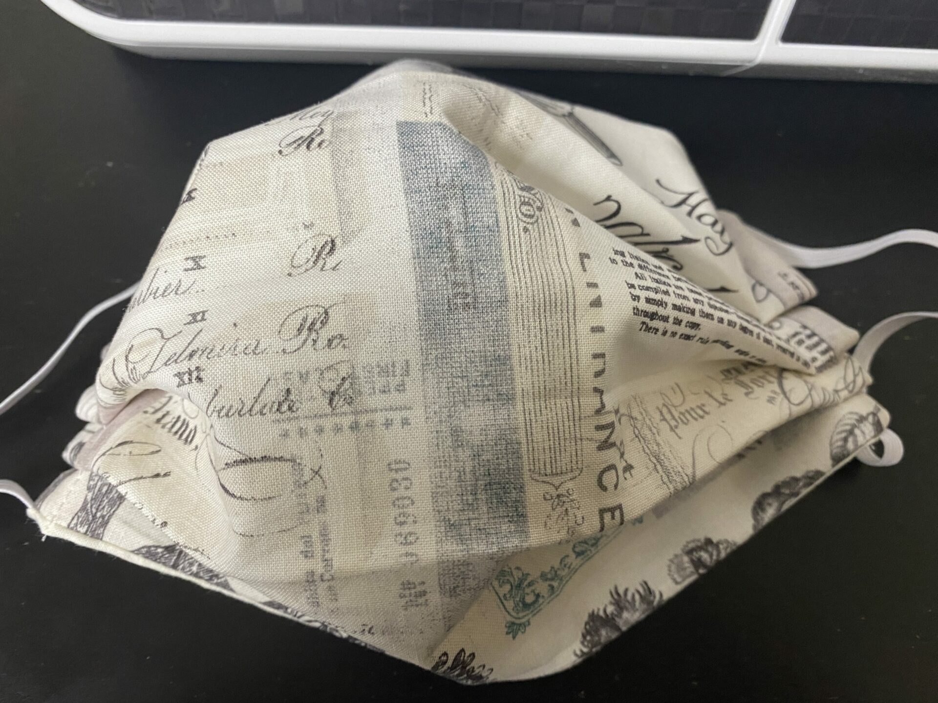 Vintage Text Face Mask - a face mask with a collage of clippings of old sketches, black and white prints and vintage calligraphy.
