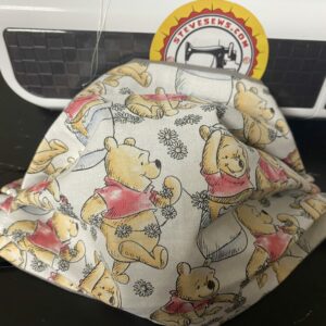 Winnie the Pooh Face Mask - this face mask is based on the Pooh Playing fabric with Winnie the Pooh on it and his honey pots. #Pooh #WinniethePooh #Honey