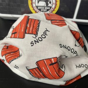 Snoopy on his Doghouse Face Mask - This face mask features Snoopy on his doghouse. #Snoopy #Doghouse