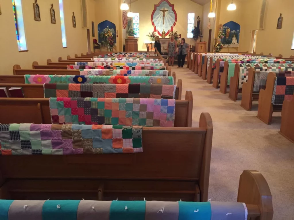 89 year old Margaret Hubl quilts were draped over each pew at her church to honor her memory. Nebraska. Courtesy of Christina Tollman 2017. Quilts on Display at Funerals - What a great way to show off all the quilts a loved one made when they pass away. #quilts #quilting 