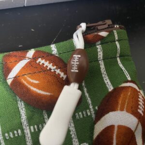 Football Zipper Pouch - This zipper pouch has a football field and a bunch of footballs on it. Great for anyone who loves football. #Football #footballfield