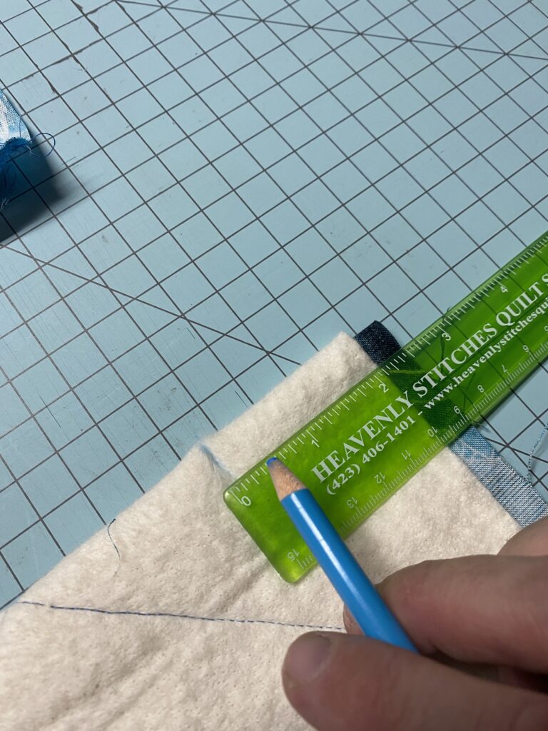 6. Using a ruler and a fabric marking pencil or chalk, Mark 2 inches over from edge of batting and 1 inch down. (Where these small pocket rulers come in handy like this one from Heavenly Stitches Quilt Shop, one of the local quilt shops I support). 