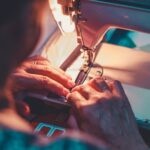 person playing sewing machine with white sewing machine