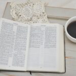 an open book and a cup of coffee on a table