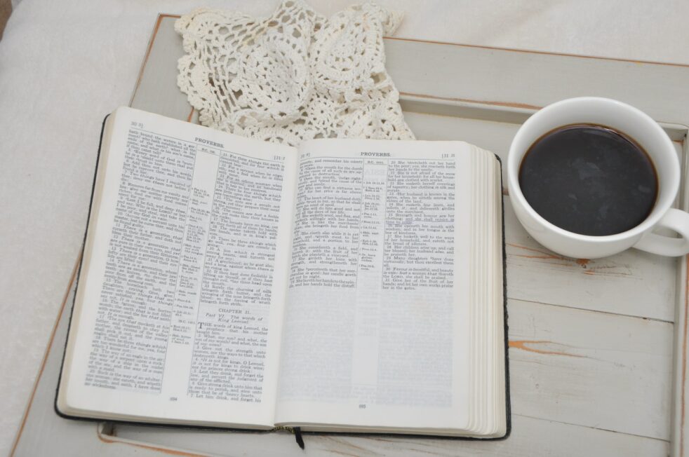 an open book and a cup of coffee on a table