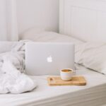 MacBook beside teacup with latte