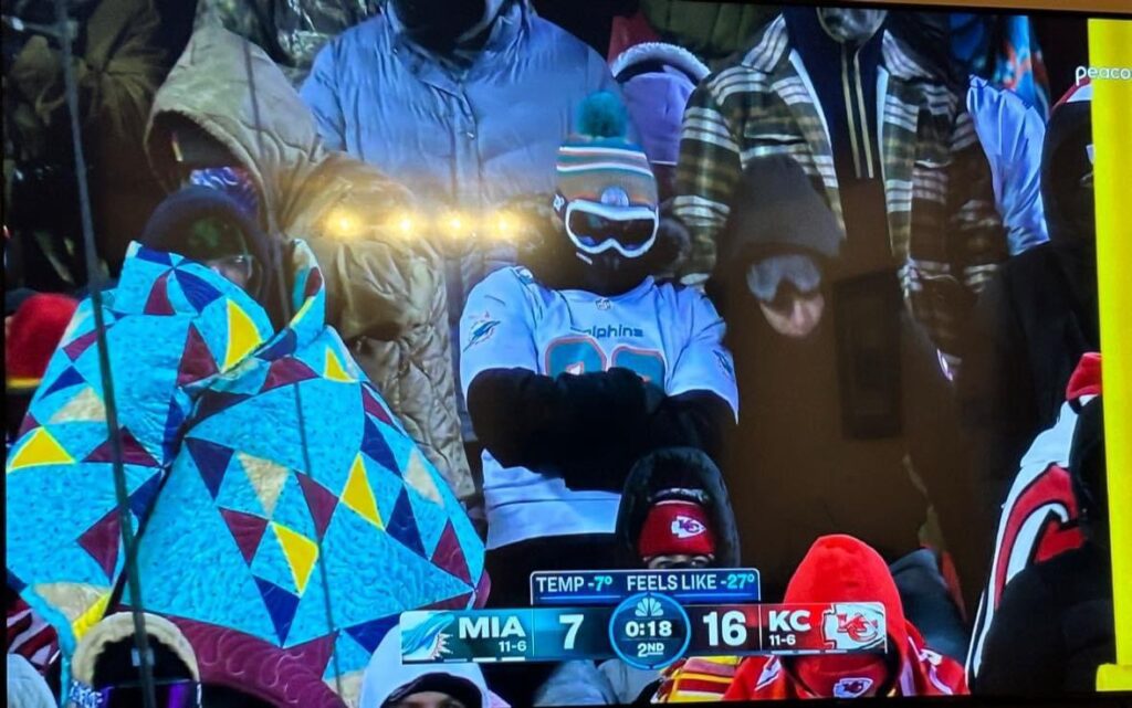 Football Fan endures the frigid cold wrapped in a quilt -  the fan embraced -7° and wind chill makes it feel like -27° at a Miami Dolphins vs Kansas City Chiefs NFL Wildcard game. 