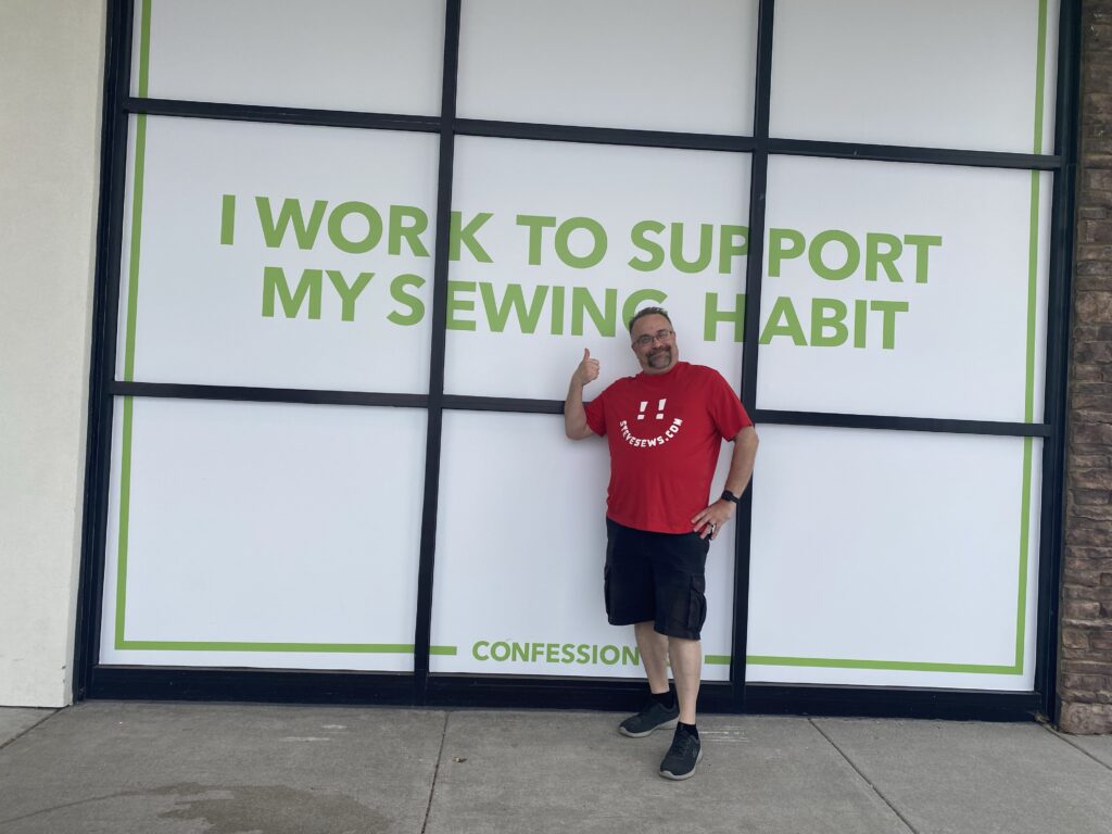 I work to support my sewing habit - Steve stops to pose with this window at the JoAnn’s in Knoxville, TN two different times. #sewinghabit #joannstore #joannfabrics